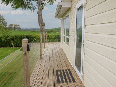 An outdoor decking area with a door at Plot 34 Carlisle