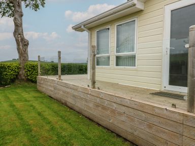 A deck area with a door and windows at Plot 34 Carlisle