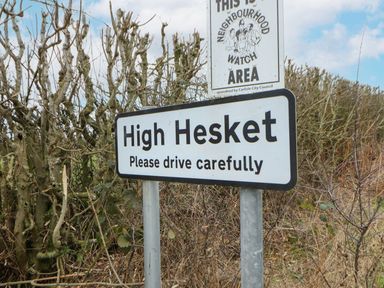 A road sign indicating High Hesket and a neighbourhood watch sign