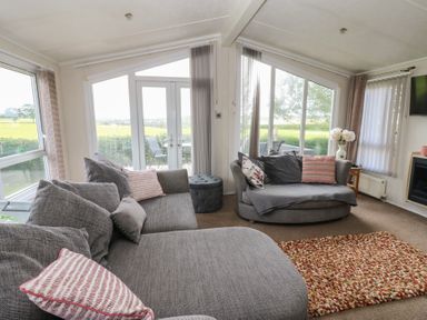 A living room with sofas and a door to the outside at Plot 34 near Armathwaite