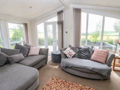 A living room with sofas and large windows at Plot 34 near Armathwaite