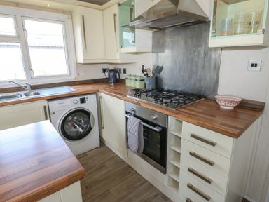 A kitchen with a washing machine and stove at Plot 34 near Armathwaite