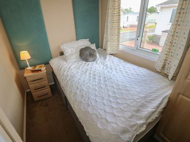 A bedroom with a single bed and bedside lamp at Plot 34 near Armathwaite