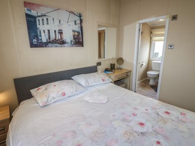 A bedroom with a bed and an attached bathroom at Plot 34 near Armathwaite