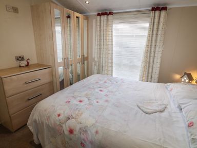 A bedroom with a bed and wardrobe at Plot 34 near Armathwaite