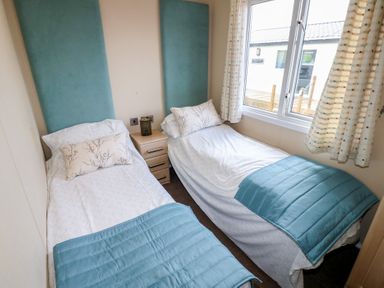 A bedroom with two single beds and a nightstand at Plot 34 near Armathwaite