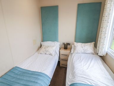 A bedroom with two beds and a nightstand at Plot 34 near Armathwaite