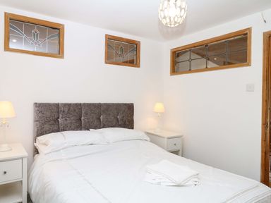 A bedroom with a bed and bedside lamp at The Headmasters Quarters in Chudleigh