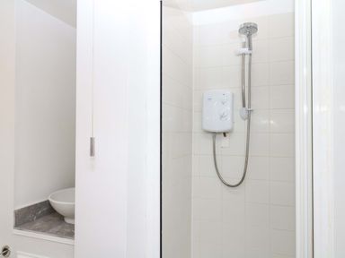 A shower with a showerhead and control unit in a bathroom at The Headmasters Quarters Chudleigh