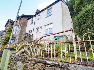 A building with a pink door and fence at Hafanedd in Betws-y-Coed