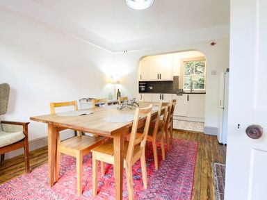 A dining room with a table and chairs and a kitchen area at Hafanedd in Betws-y-Coed