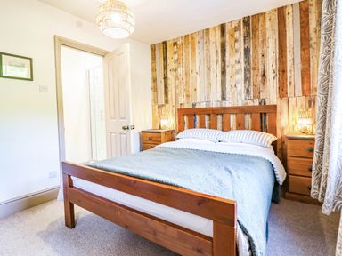 A bedroom with a wooden bed and nightstand at Hafanedd in Betws-y-Coed