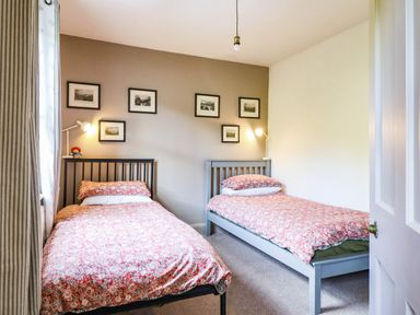 A bedroom with two beds and framed pictures at Hafanedd in Betws-y-Coed