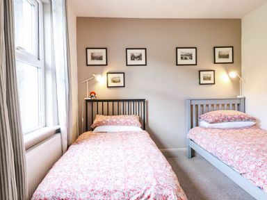 A bedroom with two beds and framed pictures on the wall at Hafanedd in Betws-y-Coed