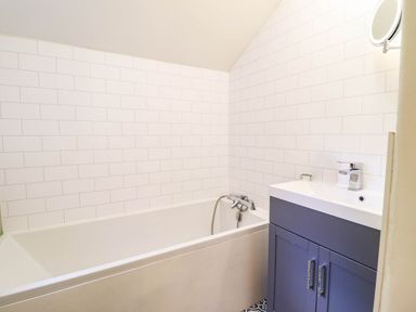 A bathroom with a bathtub and a sink at Hafanedd in Betws-y-Coed