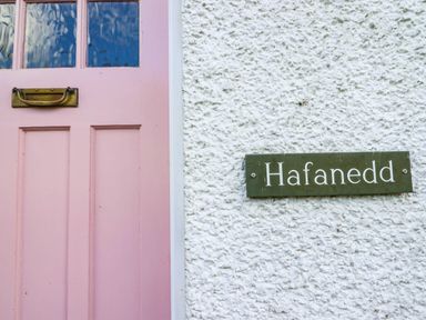 A pink door with a nameplate reading Hafanedd at Hafanedd in Betws-y-Coed