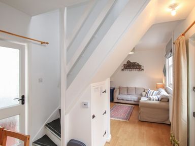 A living room with stairs and a couch at Pixie Cottage in Weymouth