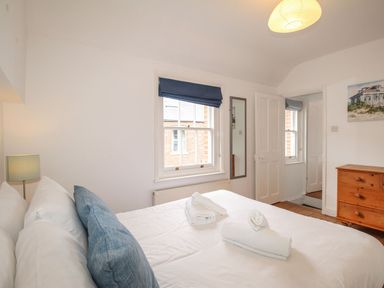 A bedroom with a bed and a chest of drawers at Pixie Cottage in Weymouth