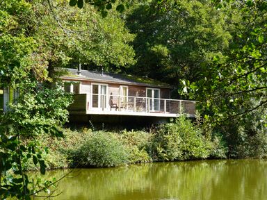 A house with a deck near a lake at 11 Water's Edge in Lanreath