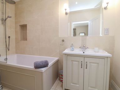 A bathroom with a bathtub, sink, and shower at Sea Vista in Westward Ho!