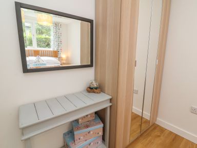 A bedroom with a mirror and a bed at Dingle Dell in Braunton