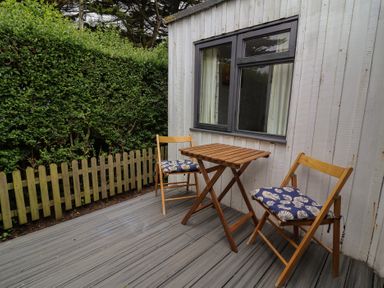 A patio with two chairs and a table at Dingle Dell in Braunton