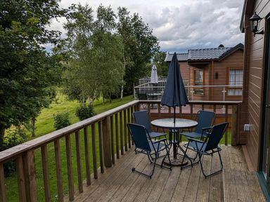An outdoor area with a table and chairs at Pet Friendly - Lodge at Riverview Holiday Park Mangerton near Newcastleton