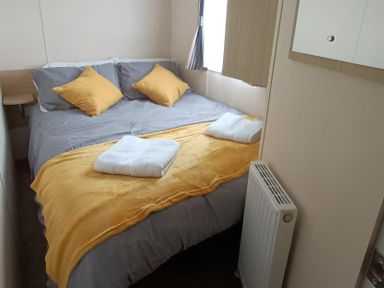 A bedroom with a double bed and towels at 3 Bed, Sleeps 6, Parking