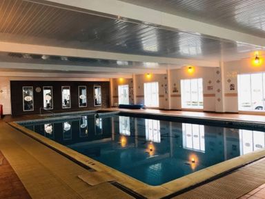 An indoor pool with large windows and lighting at 3 Bed, Sleeps 6, Parking