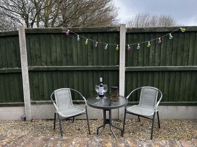 An outdoor seating area with a table and chairs at TBC in 