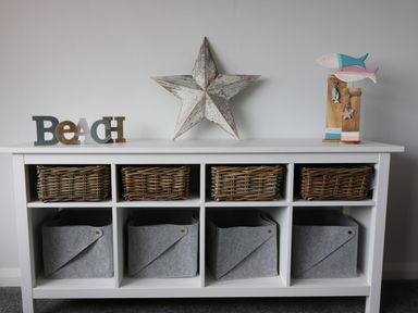 A shelf with woven baskets and decorative items at The Cartwheel in Amroth