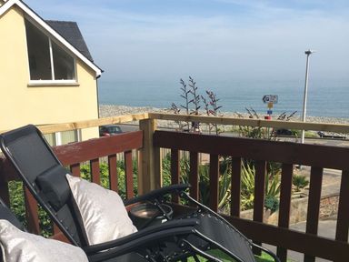 A deck with a chair and sea view at The Cartwheel in Amroth