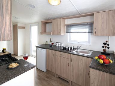 A kitchen with a sink and fridge at Tide’s Reach - Hayling Island