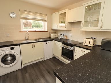 A kitchen with appliances and cabinetry at Sarah's Cottage