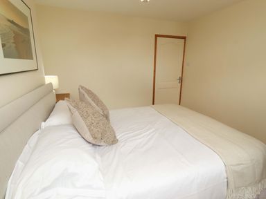 A bedroom with a bed and lamp at Sarah's Cottage