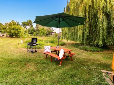 A garden with a table and grill under an umbrella at Laurel in Welney near Littleport