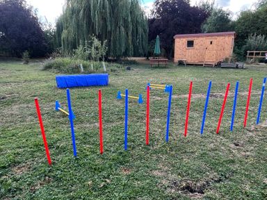 An obstacle course with colored poles and a wooden shed at Laurel in Littleport