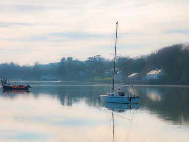 A sailboat and a fishing boat on water at Bryn Llifon in Pentraeth