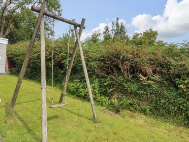 A swing set in the garden at Red Wharf Retreat near Benllech