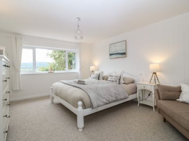 A bedroom with a bed and nightstand at Red Wharf Retreat in Red Wharf Bay near Benllech