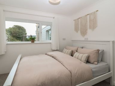 A bedroom with a bed and window at Red Wharf Retreat Red Wharf Bay near Benllech