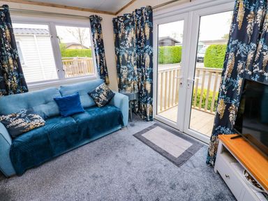 A living room with a sofa and television at Plot 41 High Hesket near Armathwaite