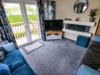 A living room with a television and sofa at Plot 41 High Hesket near Armathwaite
