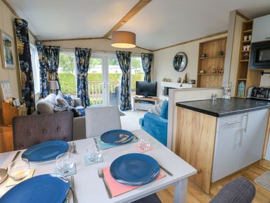 A living room with a dining area and television at Plot 41 High Hesket near Armathwaite
