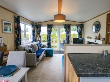 A living room with a sofa and a television at Plot 41 High Hesket near Armathwaite