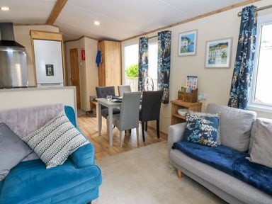 A living room with a sofa and dining area at Plot 41 High Hesket near Armathwaite