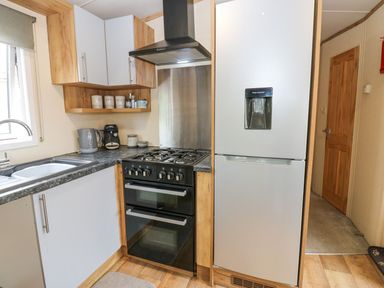 A kitchen with a stove and refrigerator at Plot 41 High Hesket near Armathwaite