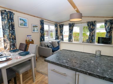 A living room with a dining area and a sofa at Plot 41 in High Hesket near Armathwaite