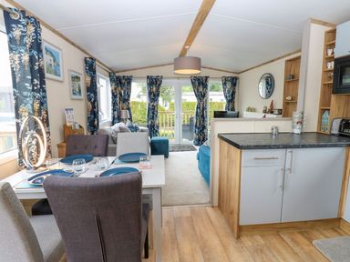 A living room with a dining area and kitchen counter at Plot 41 in High Hesket near Armathwaite