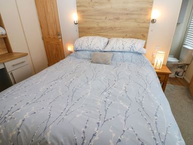 A bedroom with a bed and bedside table at Plot 41 in High Hesket near Armathwaite